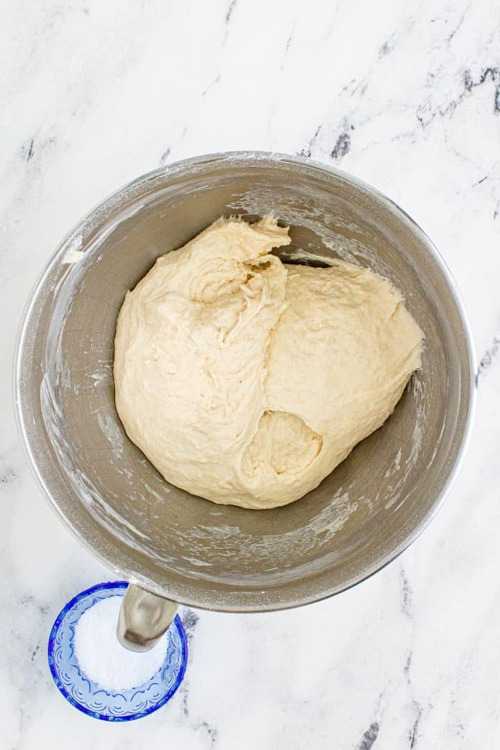 dough in a mixing bowl that has been kneaded with a hook dough attachment. 