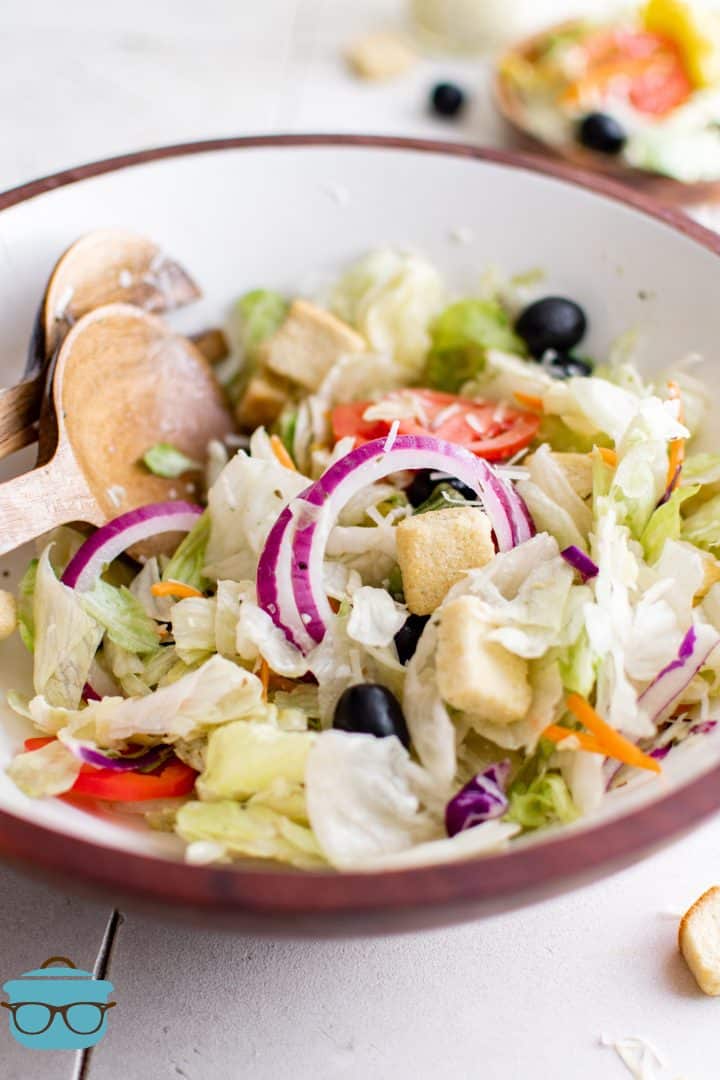 copycat Olive Garden style salad in a large bowl with salad spoons.