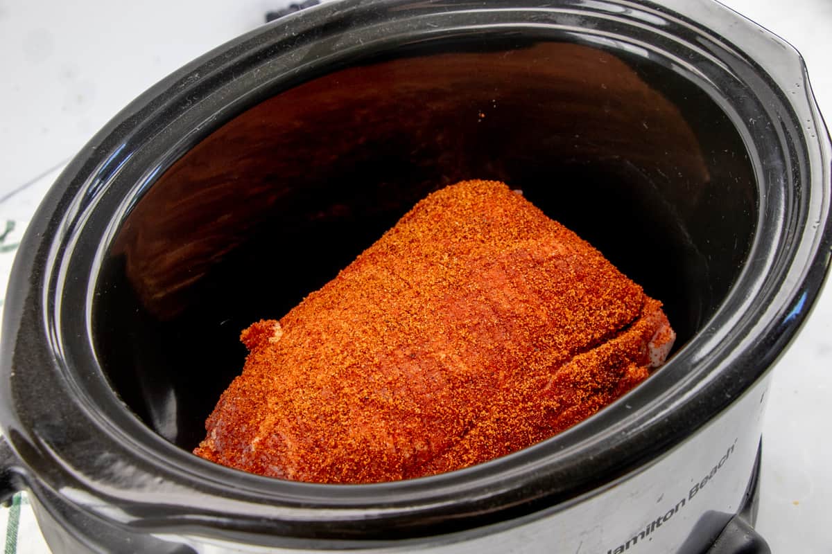 seasoned pork shoulder roast inside a 7-quart slow cooker.