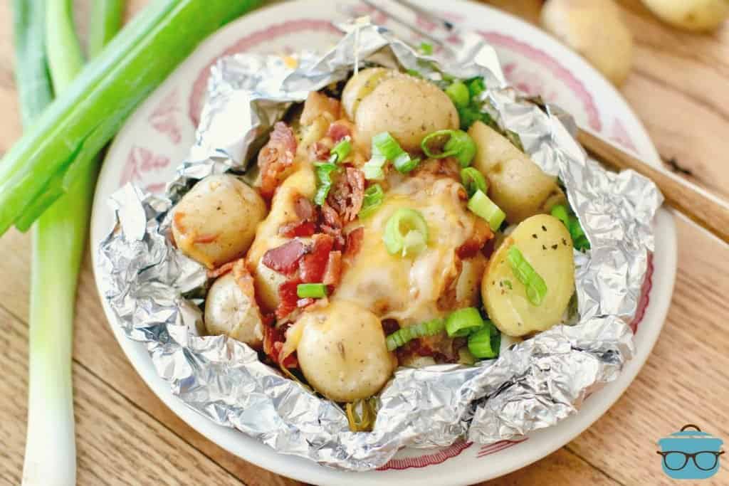 Campfire BBQ Potato Foil Packs on a plate with sliced green onions