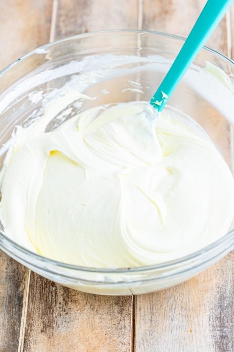 Lemon frosting and Cool Whip mixed together in a bowl.