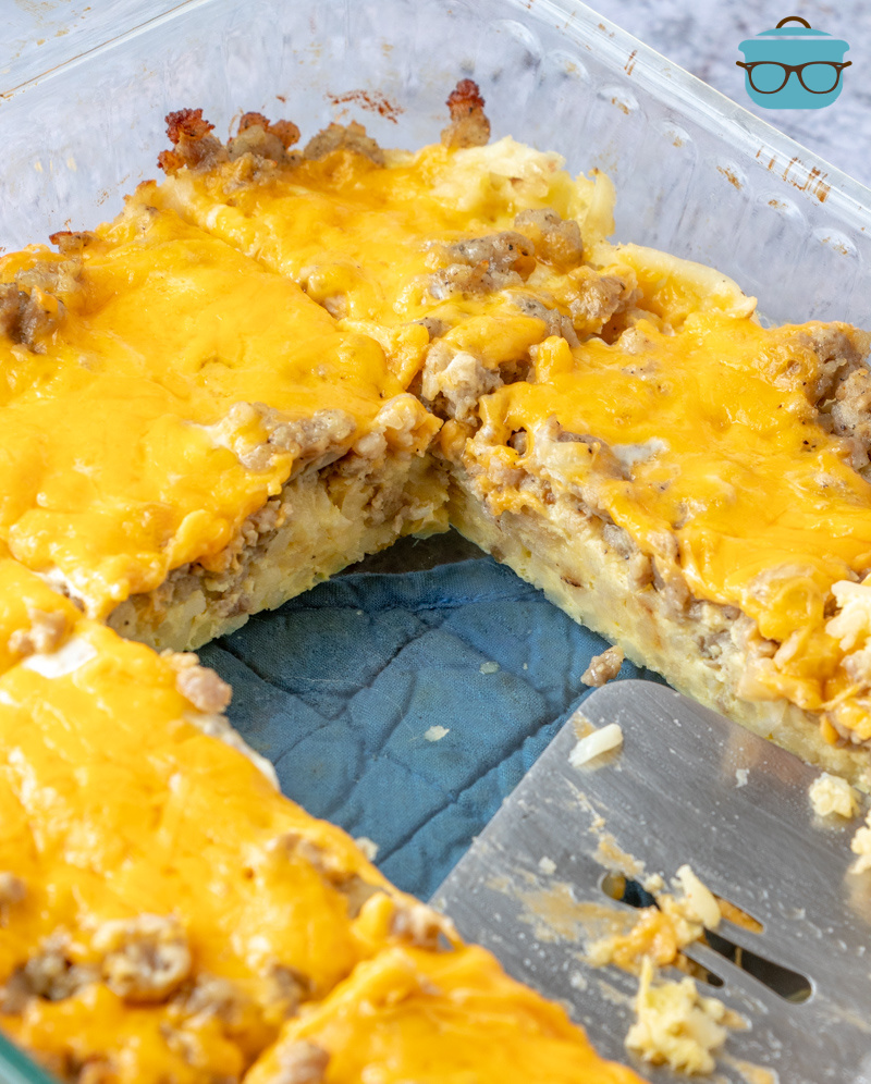a casserole dish of hash brown casserole with two slices removed. 