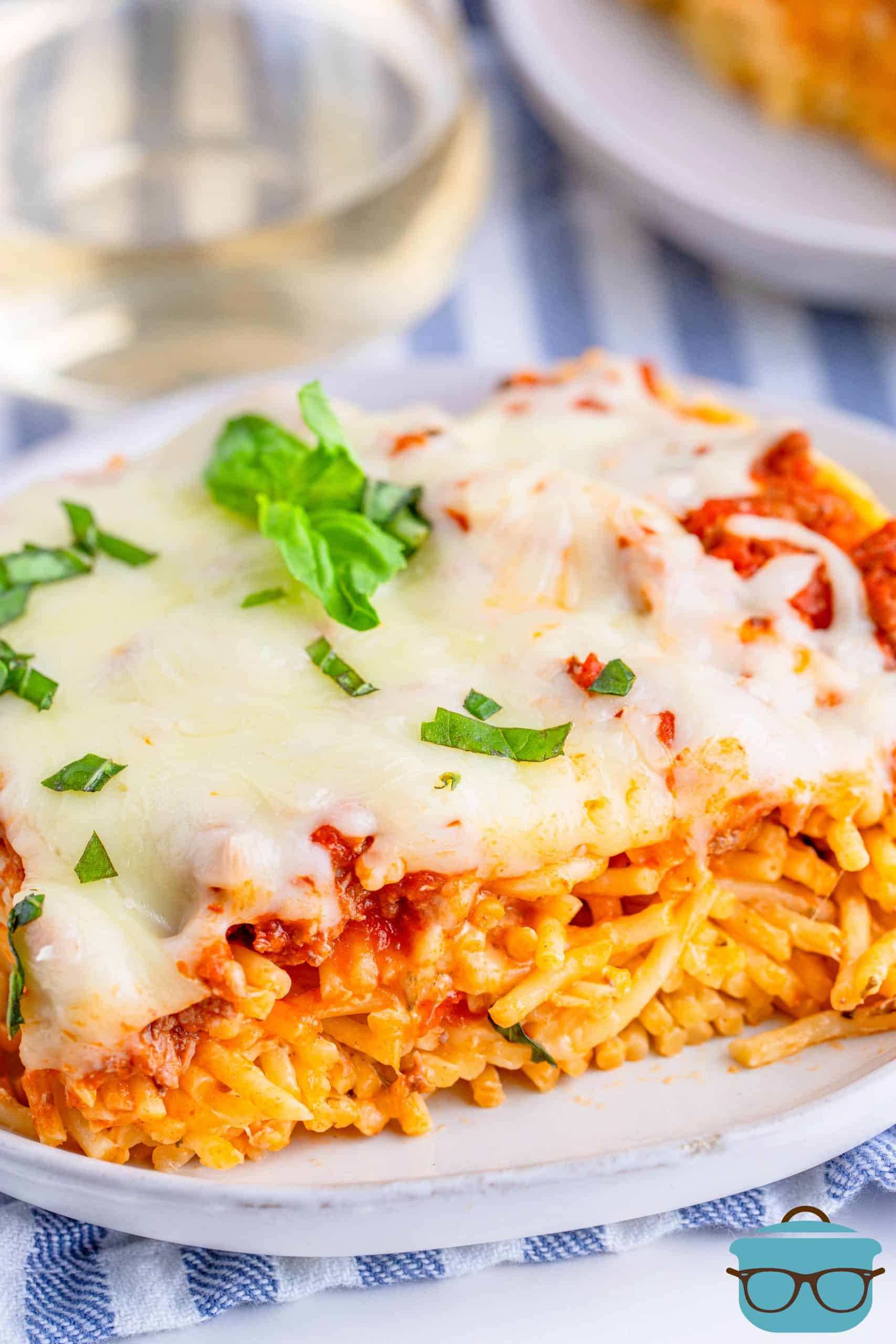 close up photo of a slice of baked spaghetti on a white plate