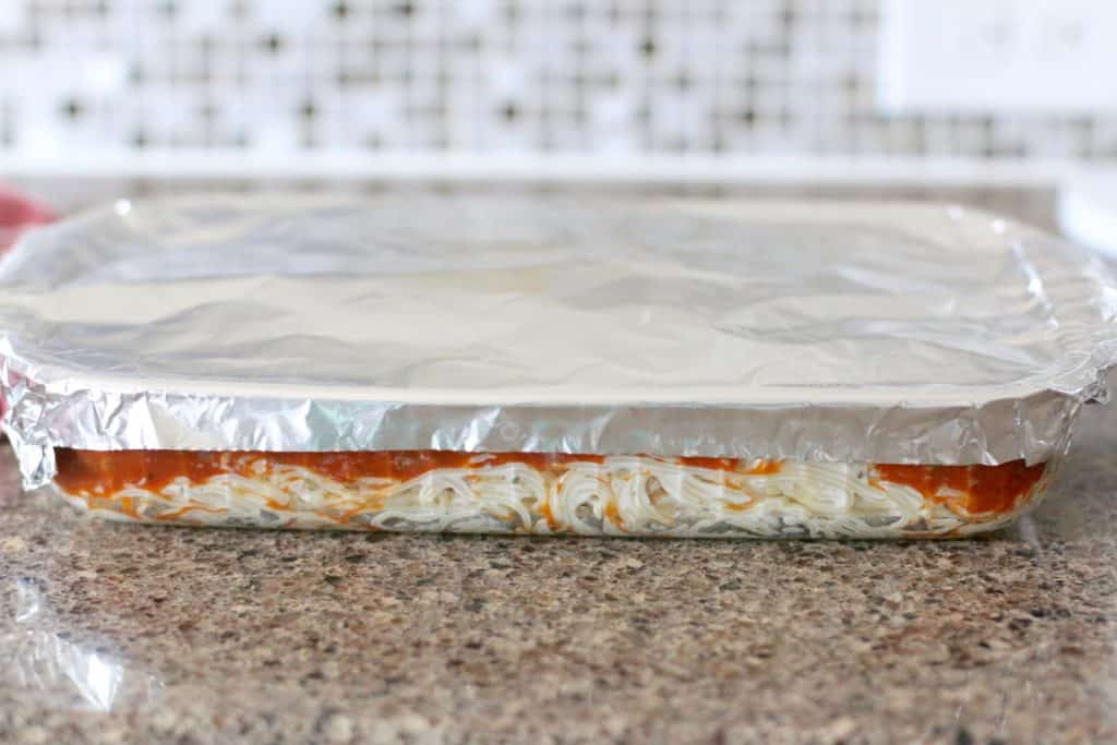 baked spaghetti casserole covered with aluminum foil 