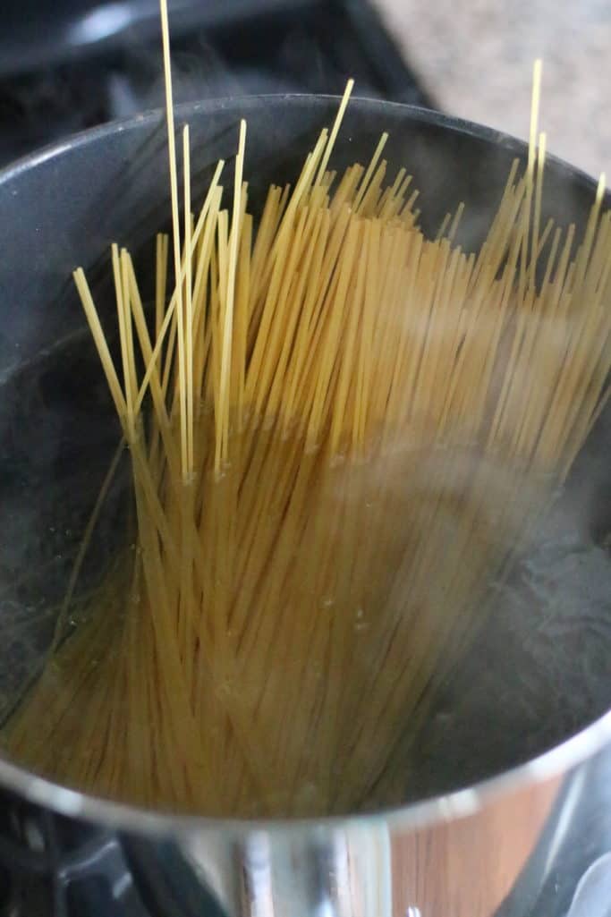 spaghetti noodles in boiling water in a large pot