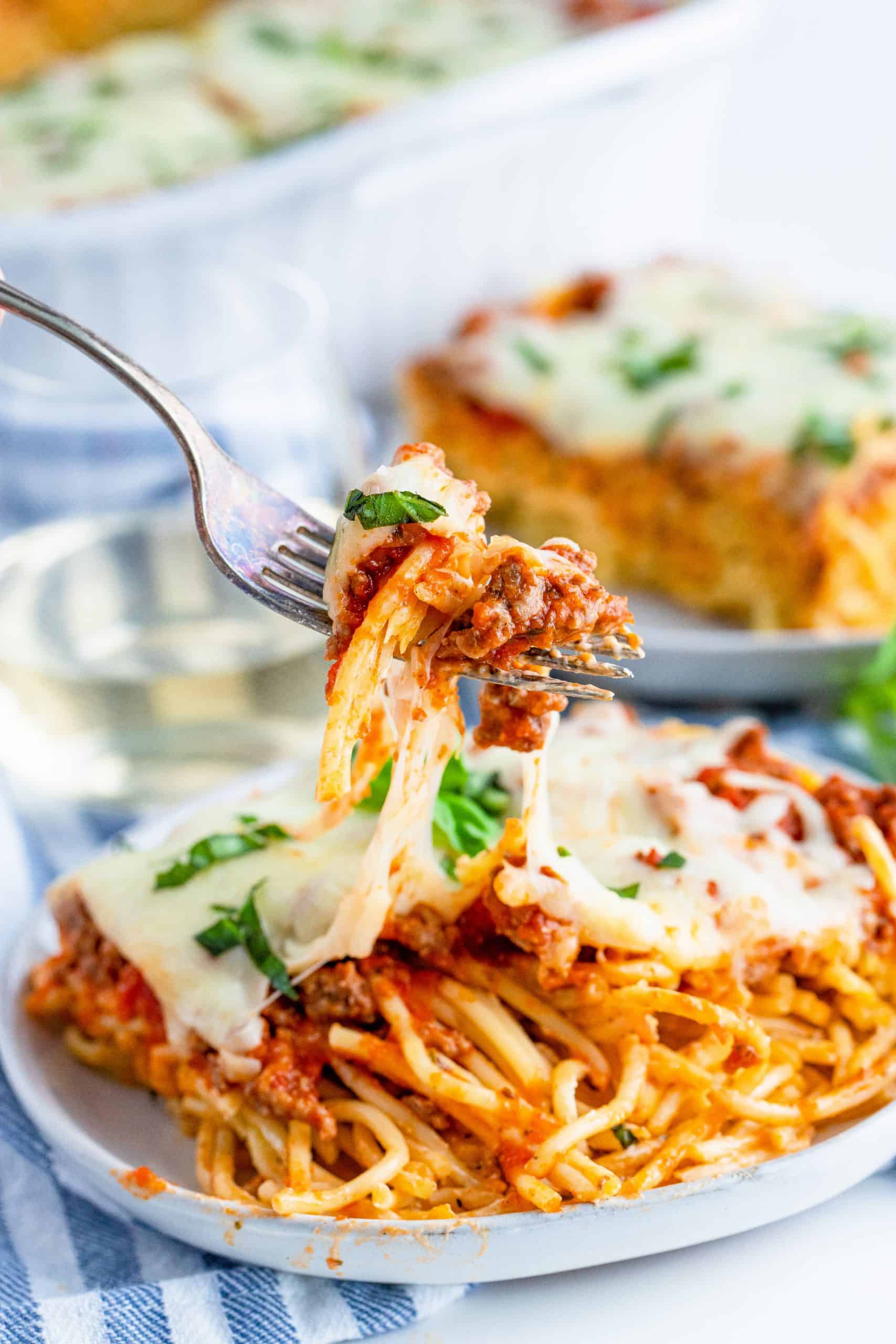 (last image) close up photo of fork pulling up a bite of Baked Spaghetti.