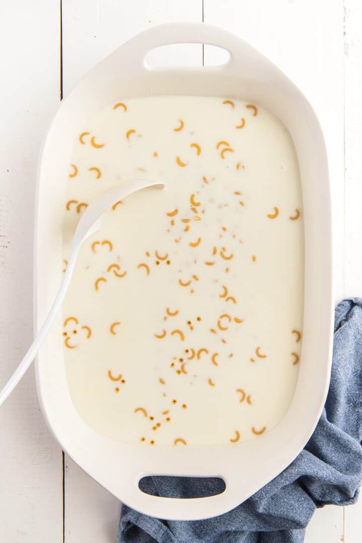 elbow macaroni added to milk in baking dish.