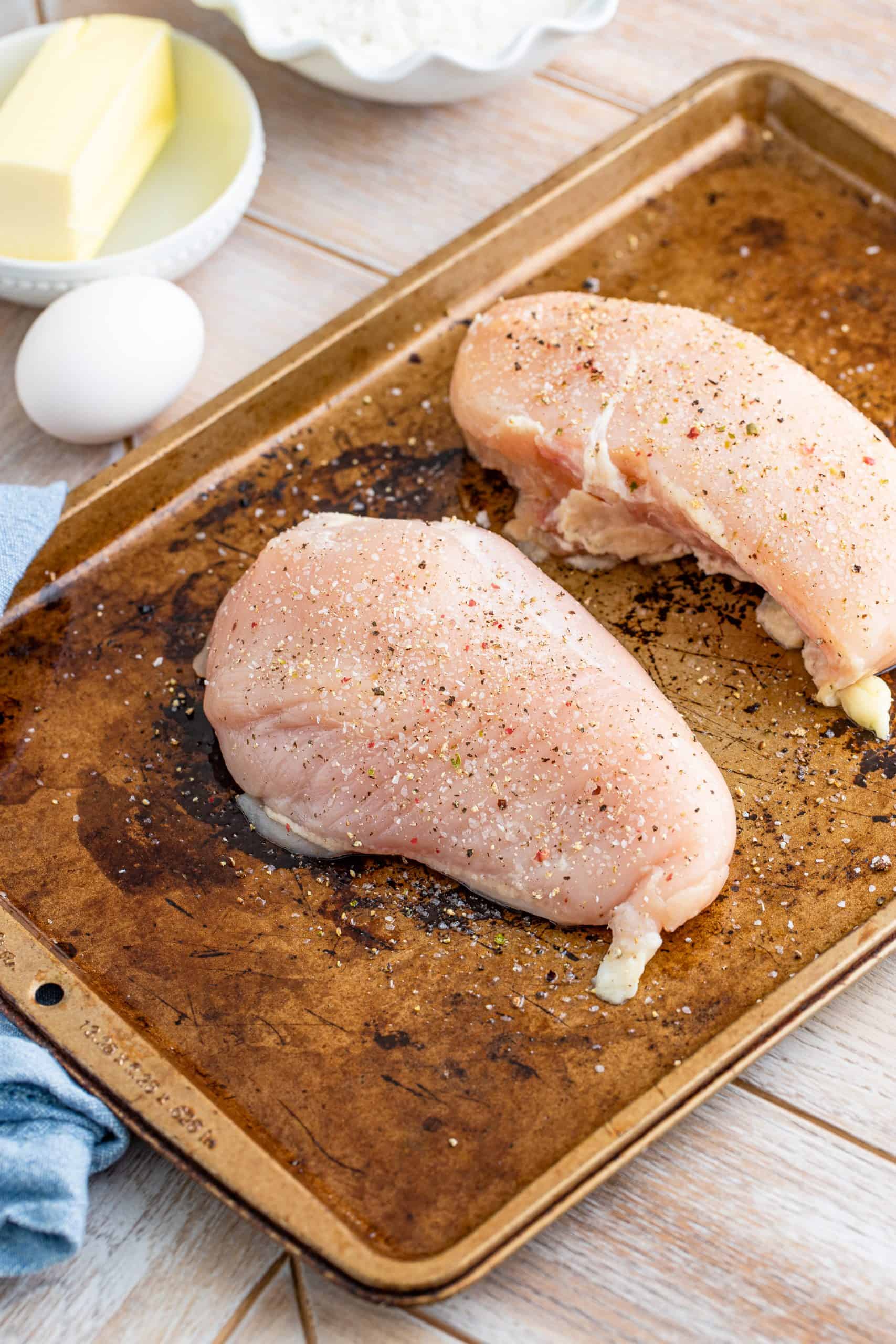 two chicken breasts on a sheet pan.