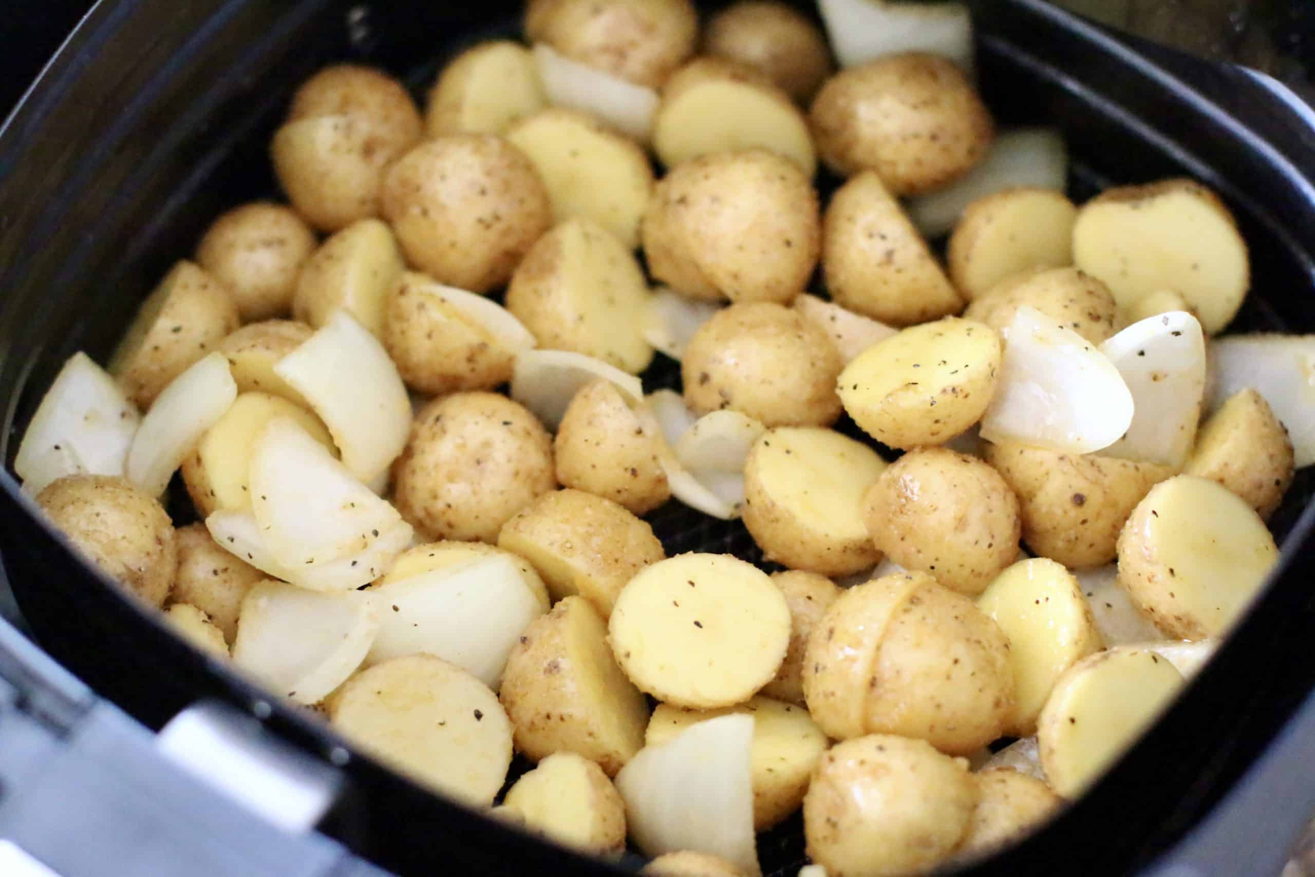 seasoned potatoes and onions in the basket of a 6-quart air fryer.