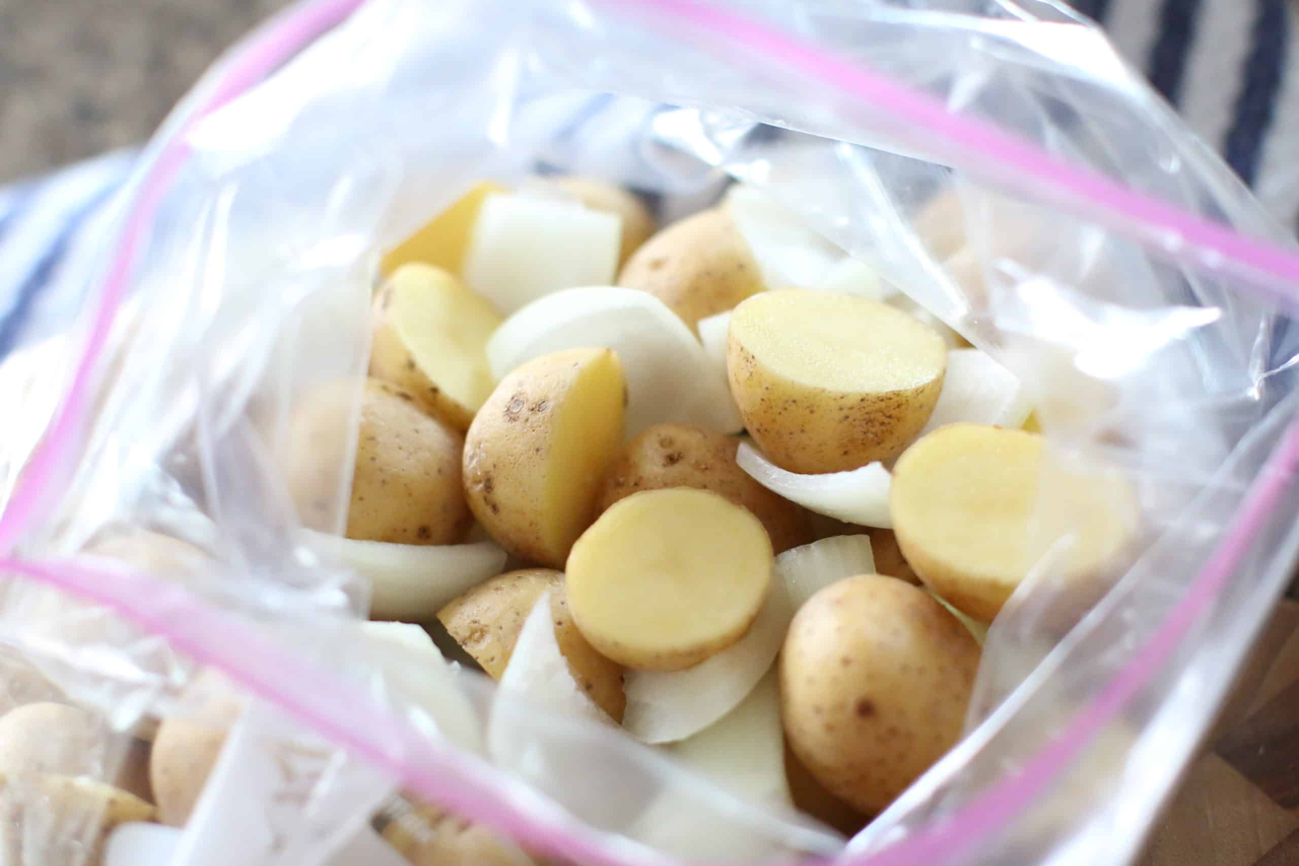 sliced potatoes and diced onion in a gallon-sized Ziploc bag.