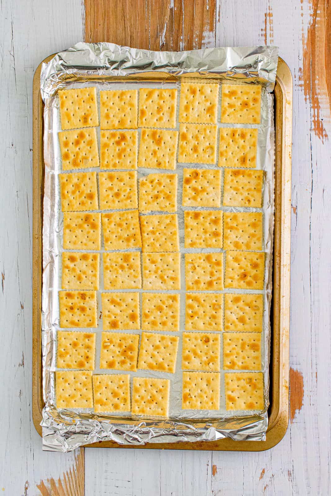 saltine crackers in a single layer on a cookie sheet.