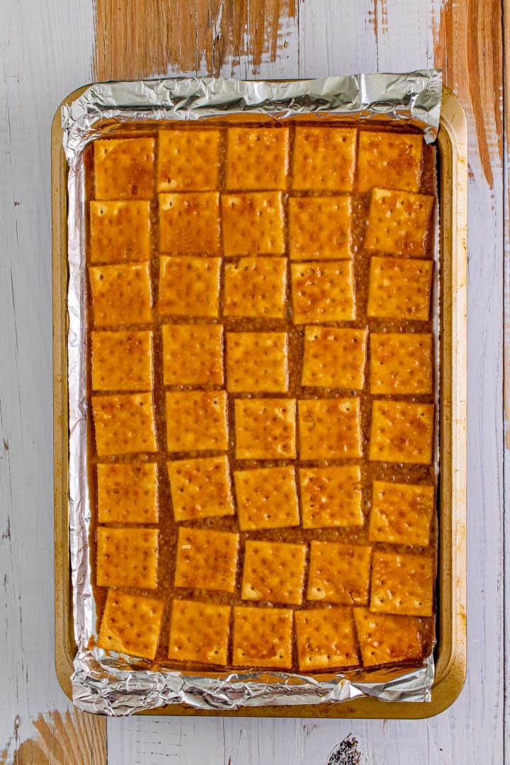 Baked cracker mixture on aluminum foil lined baking sheet.