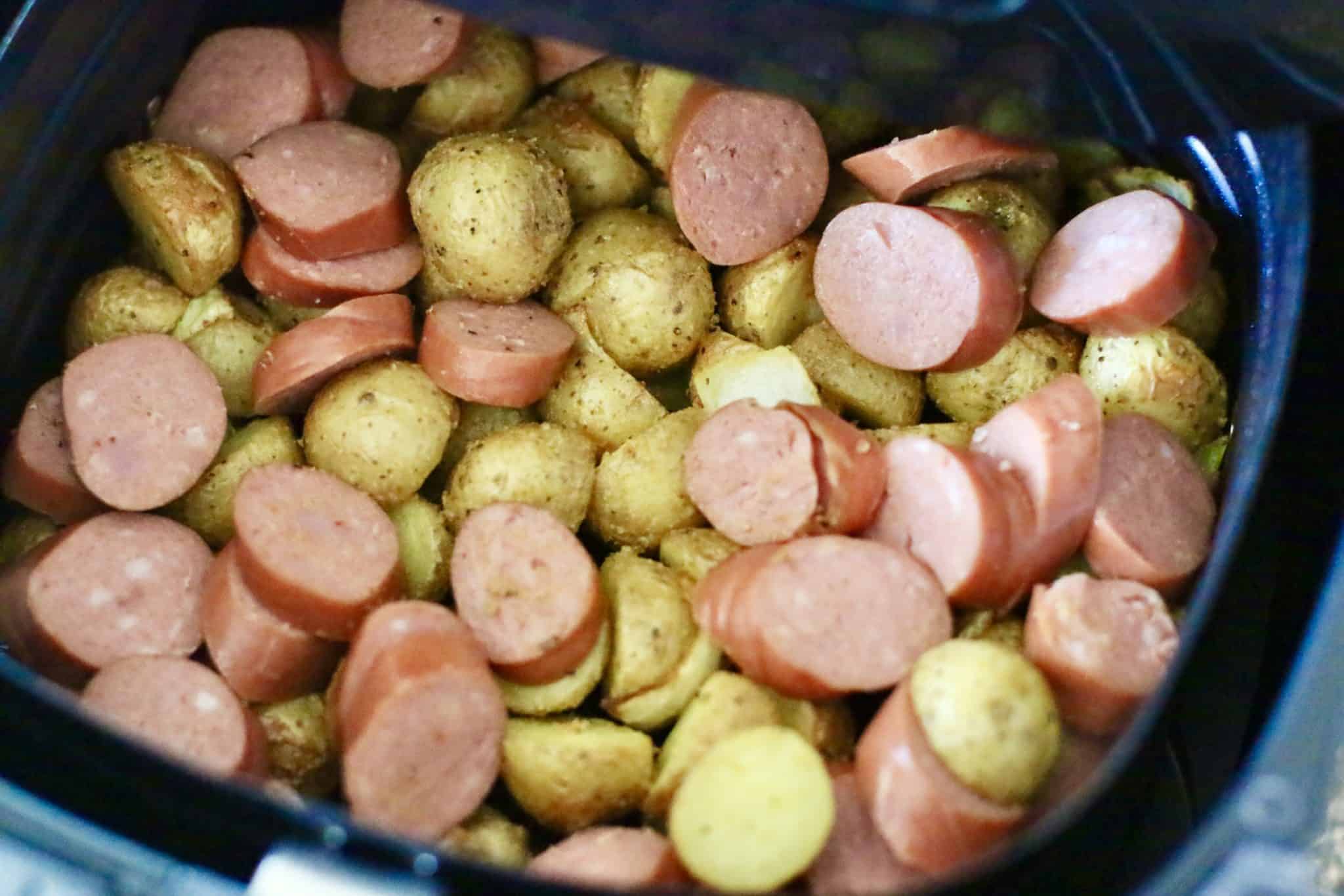 sliced smoked sausage added to cooked potatoes and onions