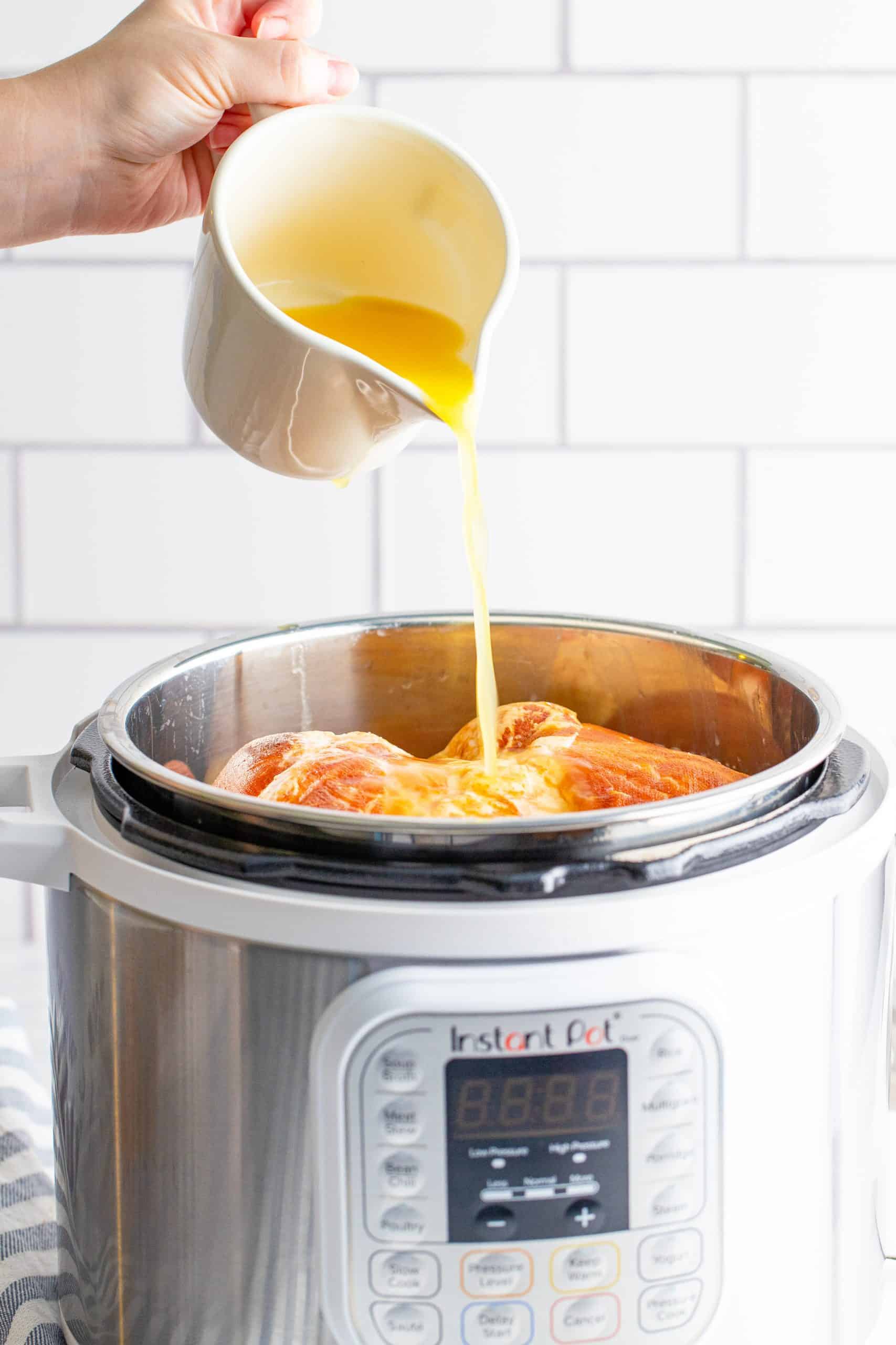 pineapple juice poured over ham inside the instant pot.