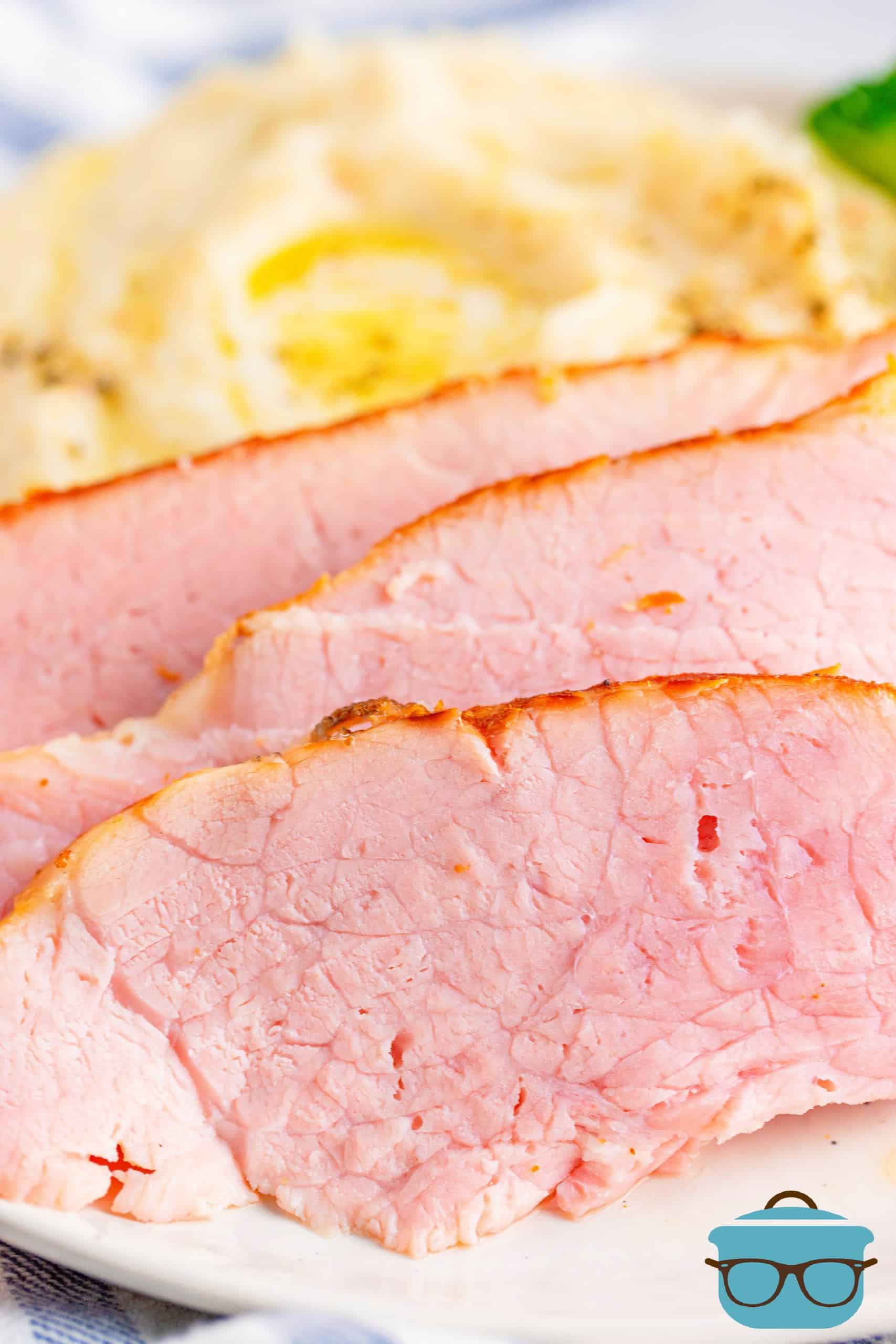 Instant Pot Ham, slices shown on a plate with mashed potatoes.