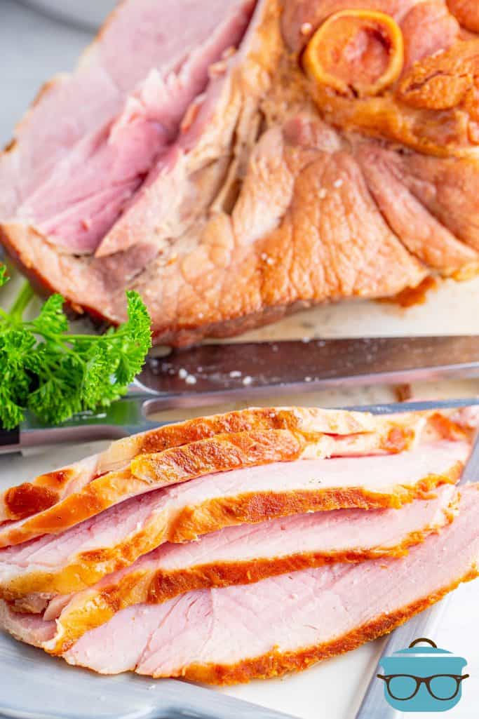 Instant Pot Sliced ham, slices shown on a white plate with the whole ham shown in the background