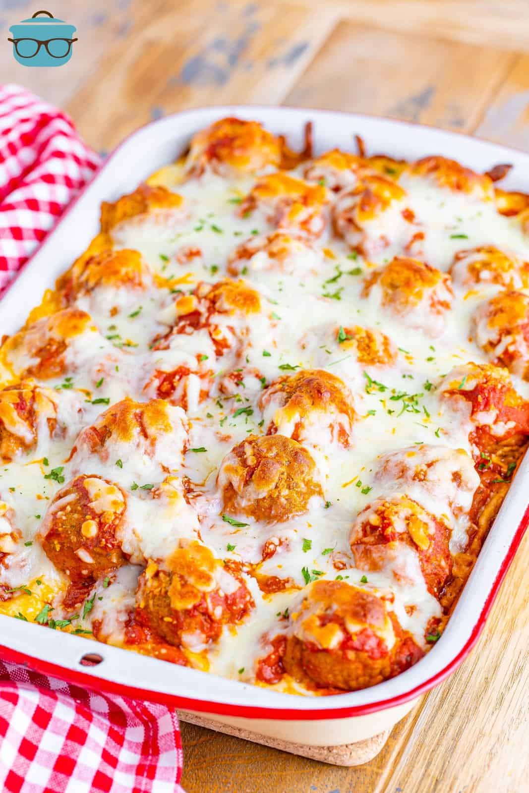 angled photo of fully cooked Meatball Sub Casserole in a white casserole dish.