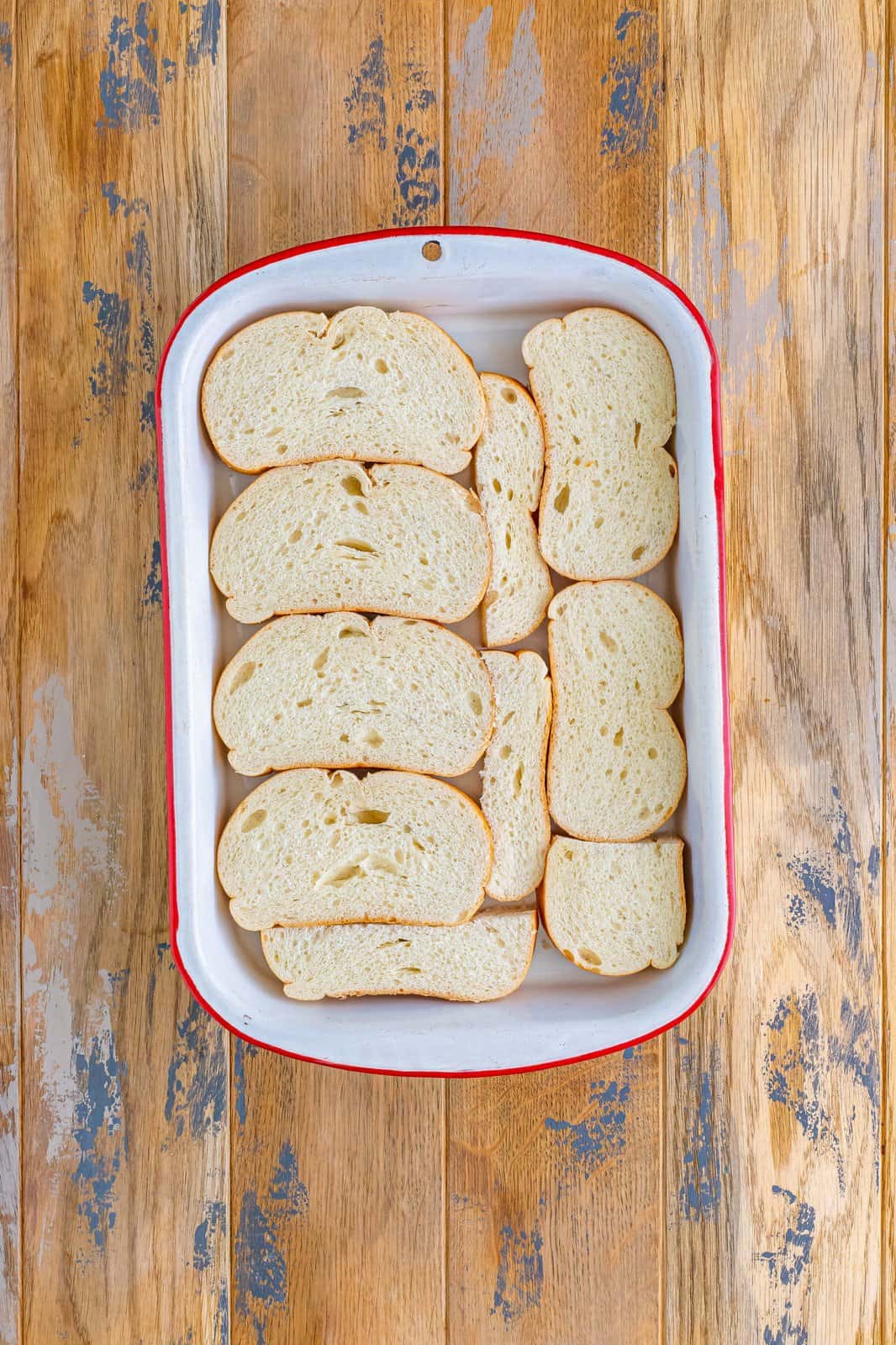 sliced Italian bread shown in an even layer in a baking dish.