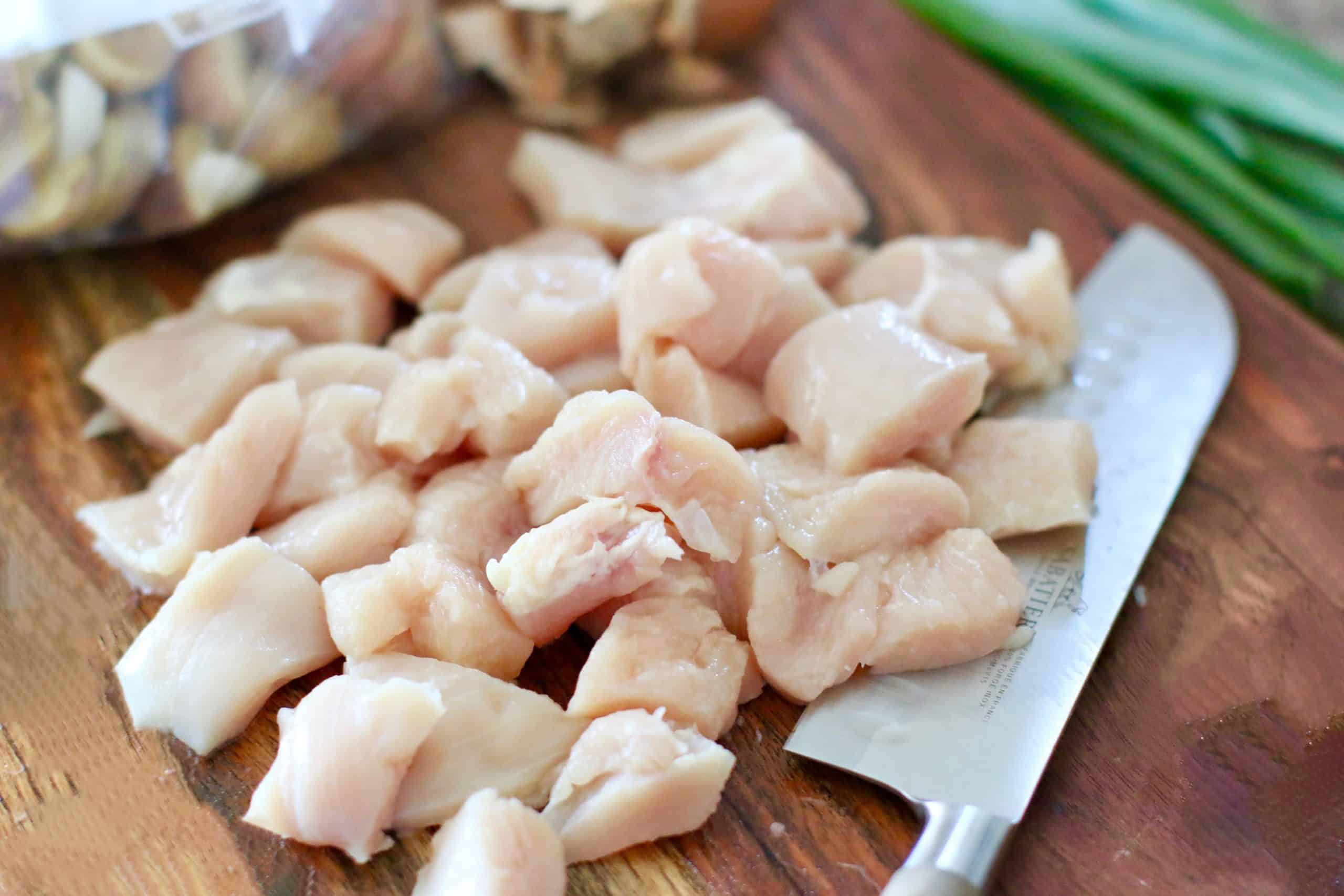 diced, fresh chicken breast on a cutting board.