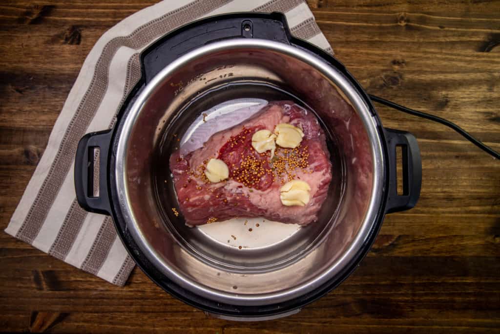 water, corned beef brisket and smashed garlic and spices in an electric pressure cooker