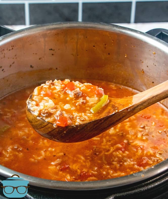 wooden spoon holding fully cooked stuffed pepper soup over bowl of Instant Pot