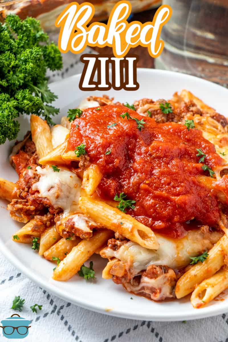 a white plate topped with baked ziti and sauce. 