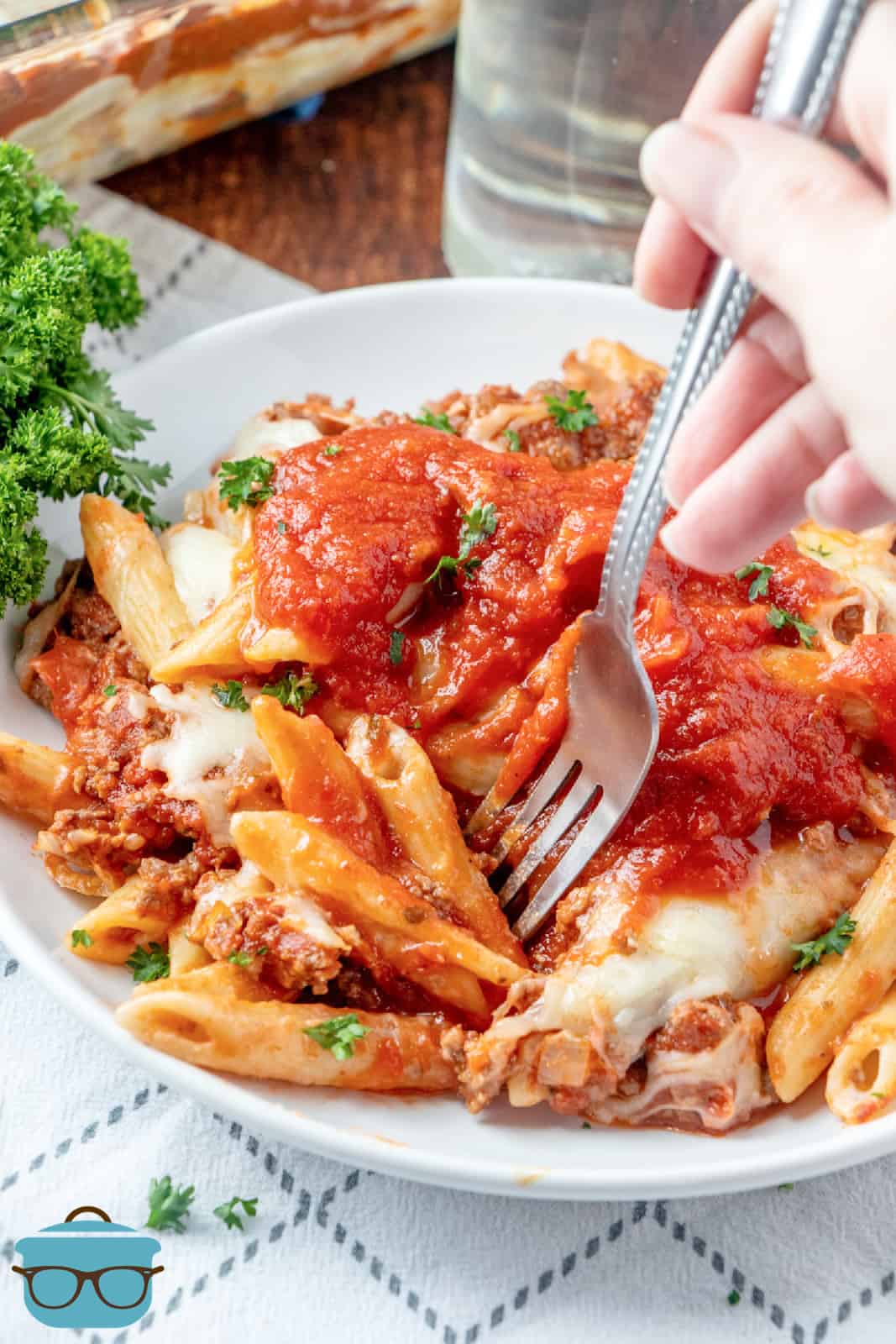 silver fork inserted into penne pasta and spaghetti sauce
