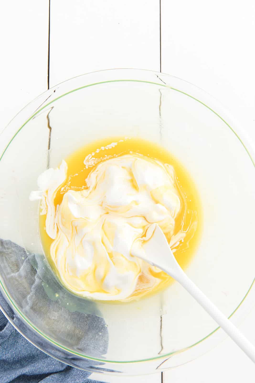 whipped topping added to pineapple juice in a bowl. 
