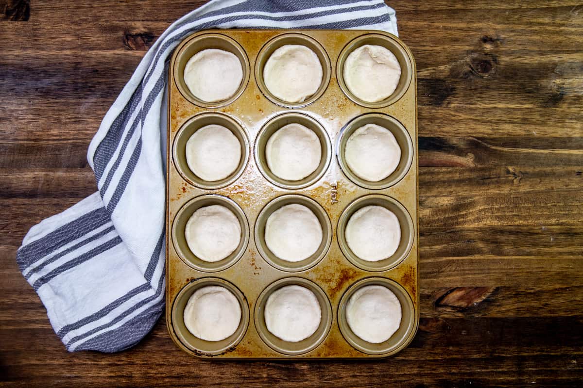 refrigerated biscuits placed into the each muffin hole in a 12-cup muffin tin.