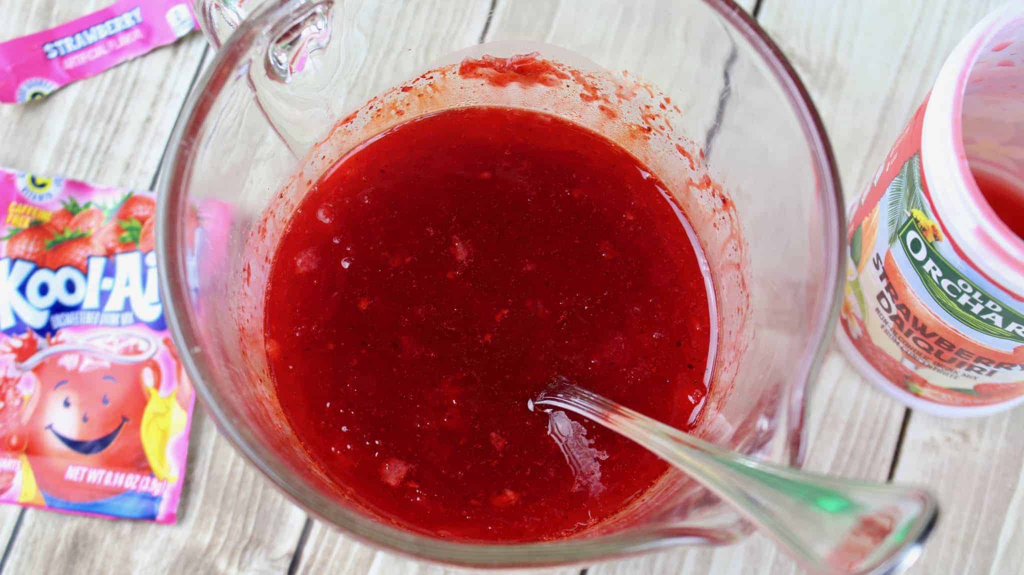 mixing strawberry daiquiri concentrate with kool aid packet.