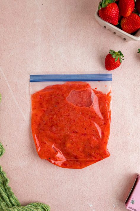 Smashed strawberries in a Ziploc bag.