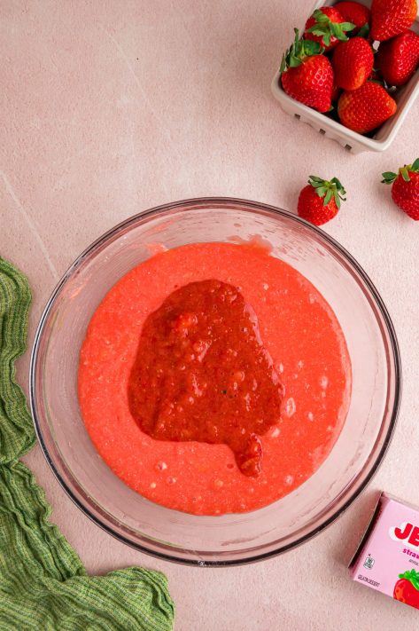 Strawberries being added to cake batter.