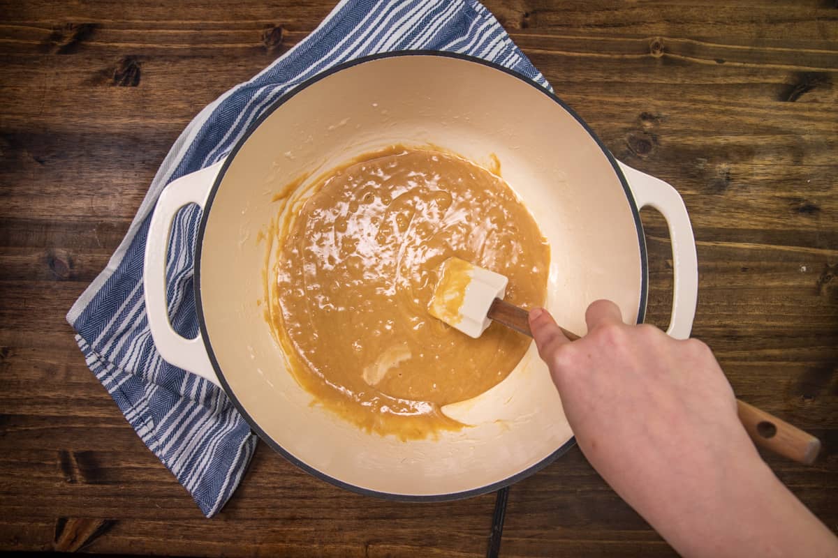 completely combined, peanut butter, marshmallows and butter being stirred with a white spatula in a pot