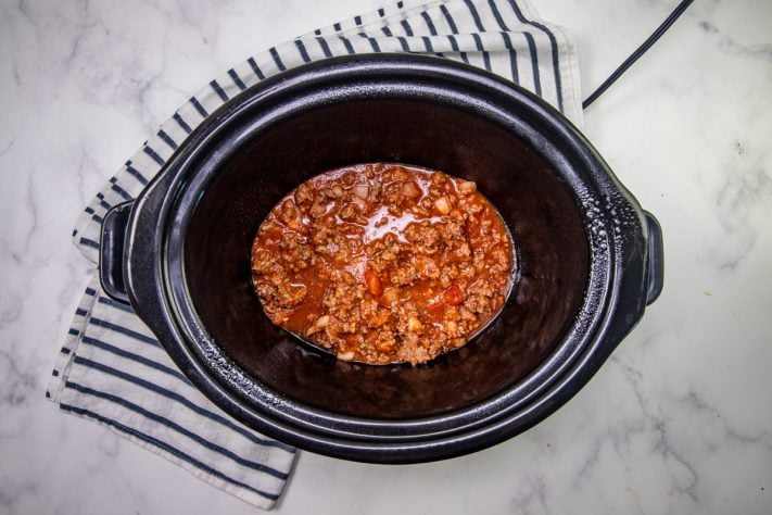 spaghetti meat sauce spread into the bottom of the slow cooker.