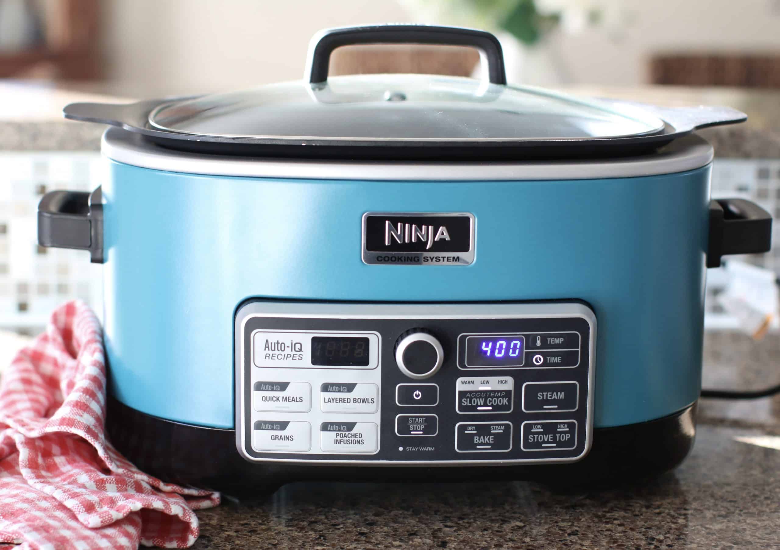 covered turquoise colored slow cooker showing a 4 hour cooking time on digital display.