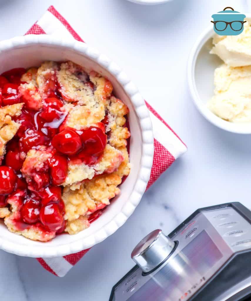 Instant Pot Cherry Cobbler shown served in a bowl with a side of vanilla ice cream