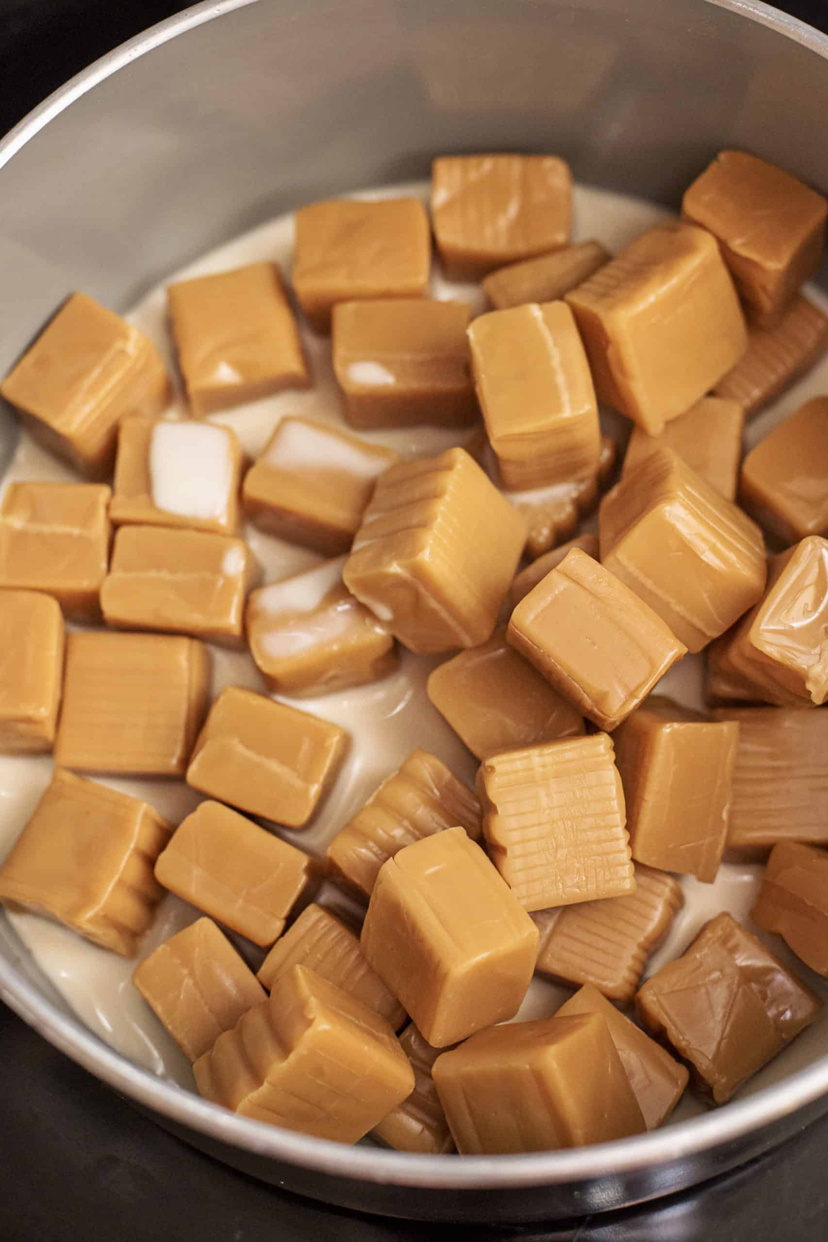 evaporated milk and caramels in the bottom of a saucepan.