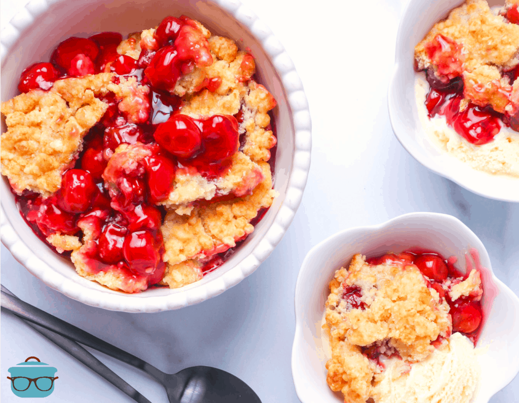 pictured, cherry cobbler served in three white bowls and scoops of vanilla ice cream