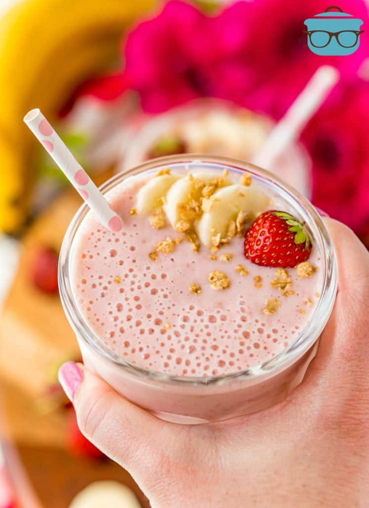 hand holding a glass filled with Strawberry Banana Smoothie