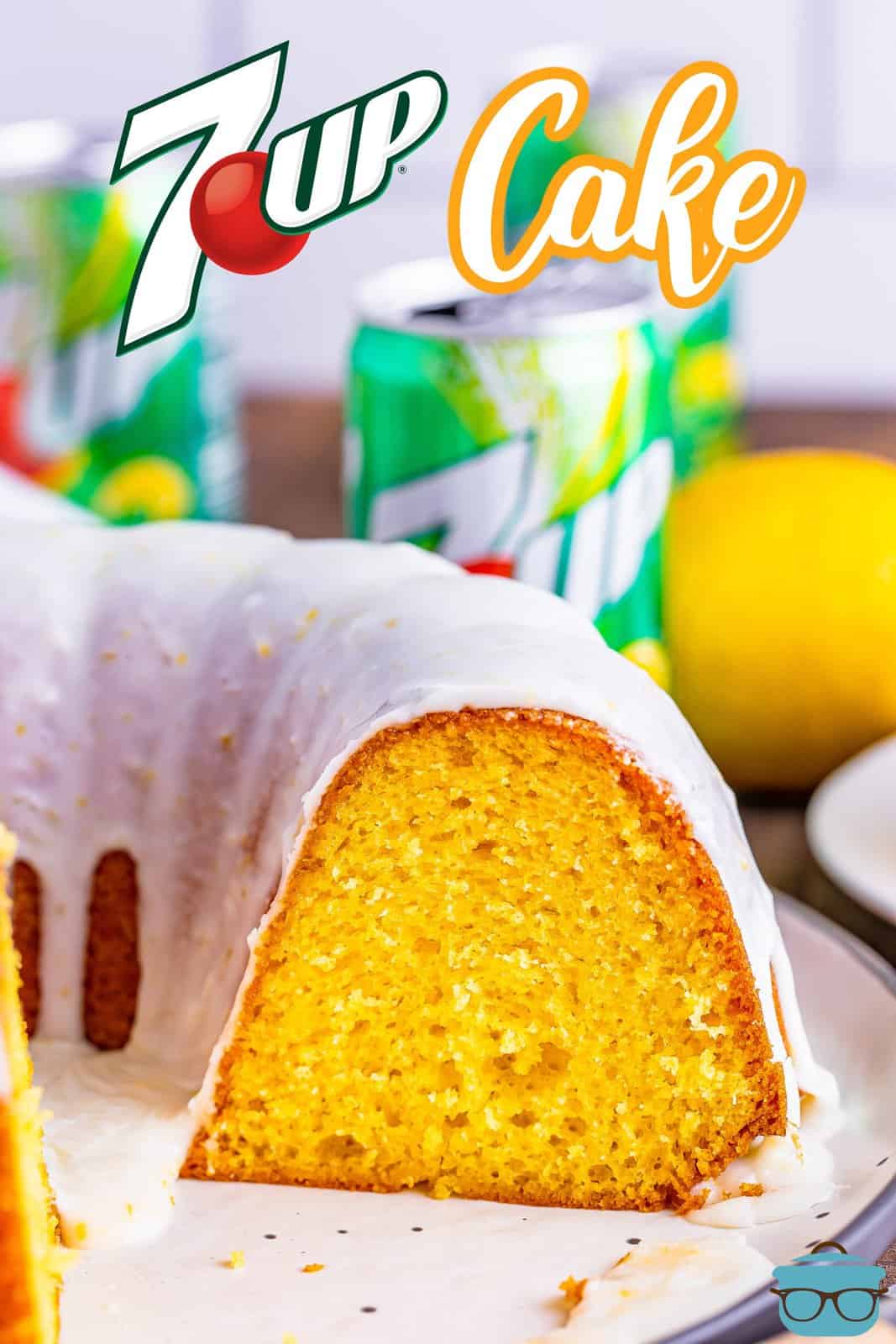 a bundt cake shown on a plate with a slice removed with cans of 7Up soda in the background.