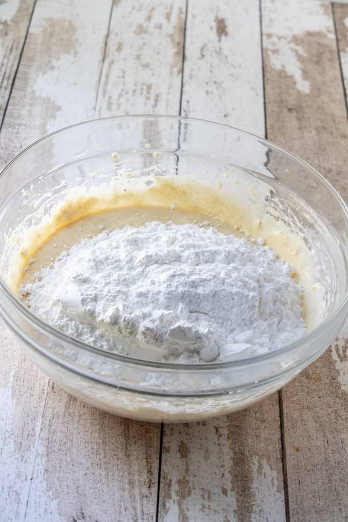 powdered sugar added to cream cheese mixture in a bowl