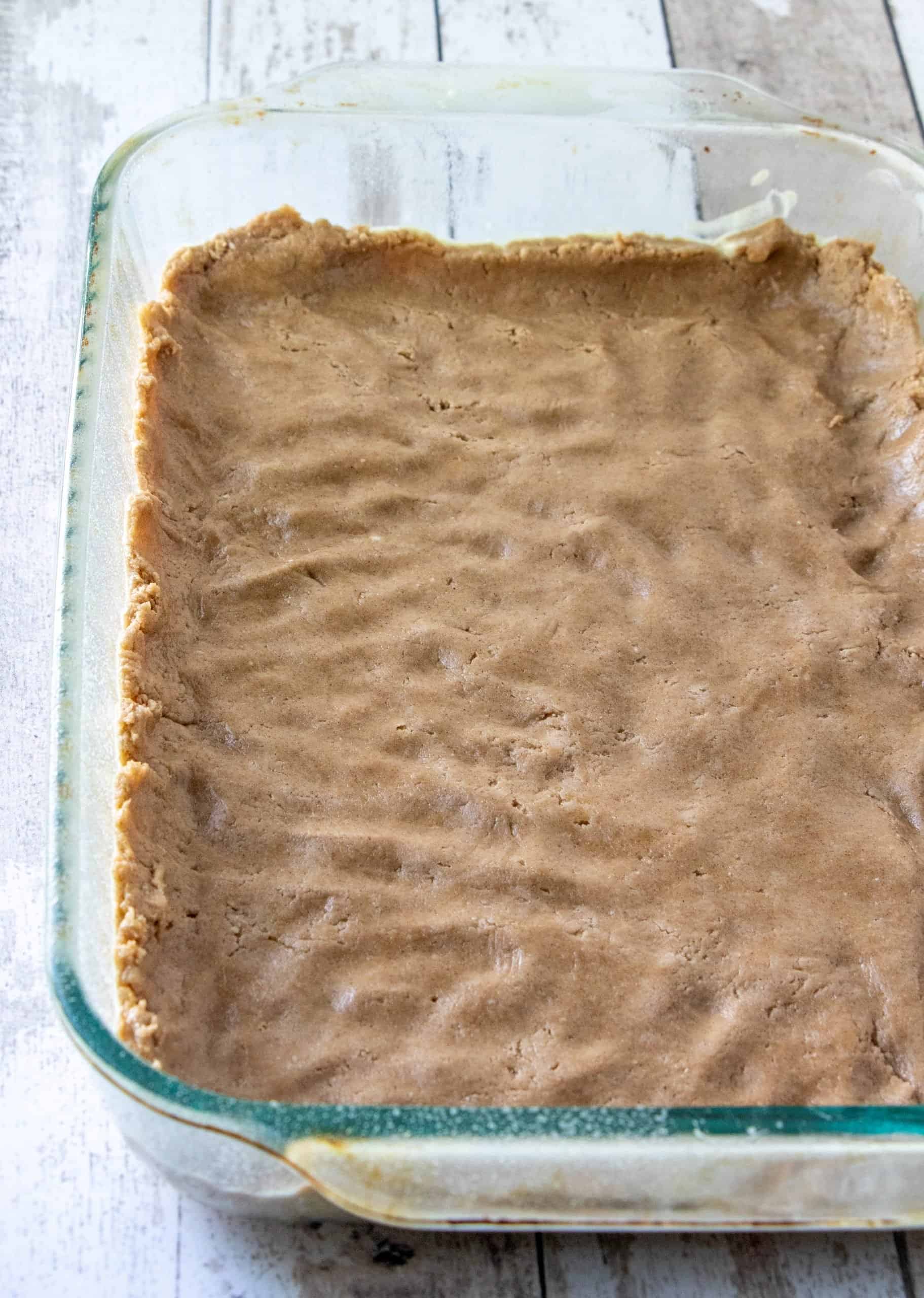 pressing cake mix mixture into the bottom of a clear baking dish.