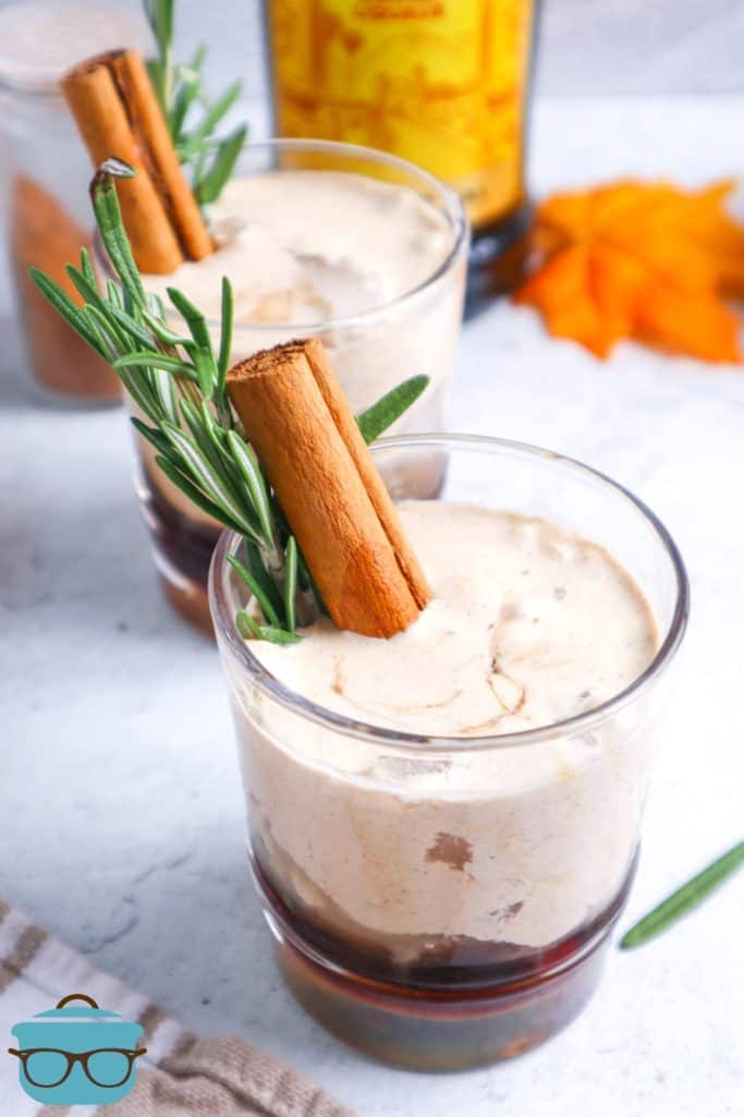 Homemade pumpkin spice White Russian shown in clear drinking glasses and served with cinnamon sticks