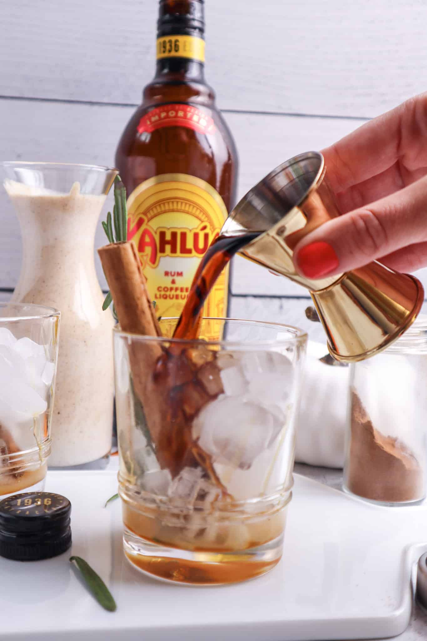 pouring Kahlua into a glass with ice