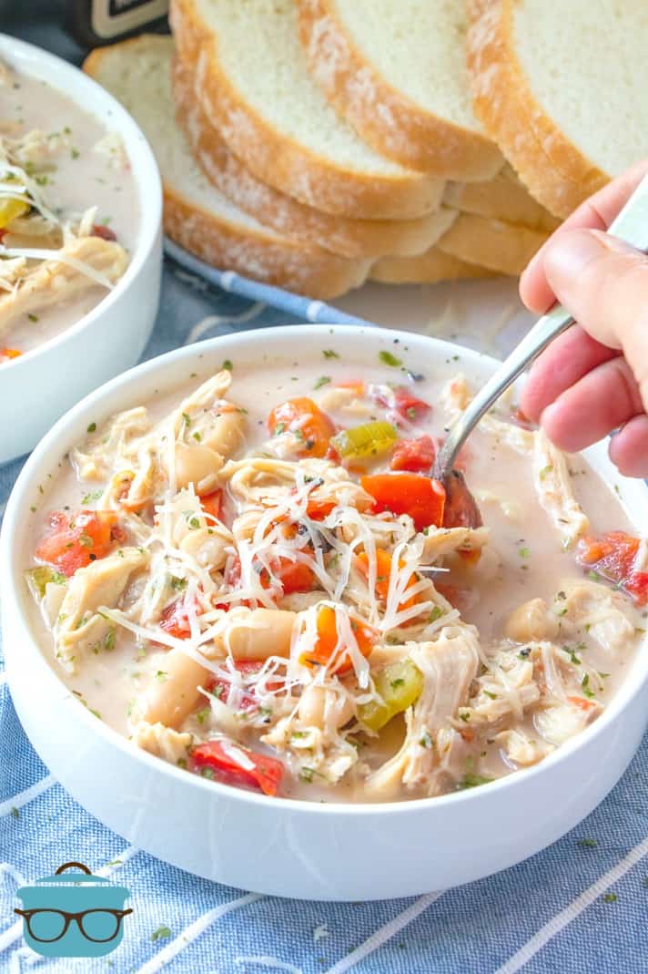 Slow Cooker Creamy Tuscan Chicken Soup, spoon shown in the soup.