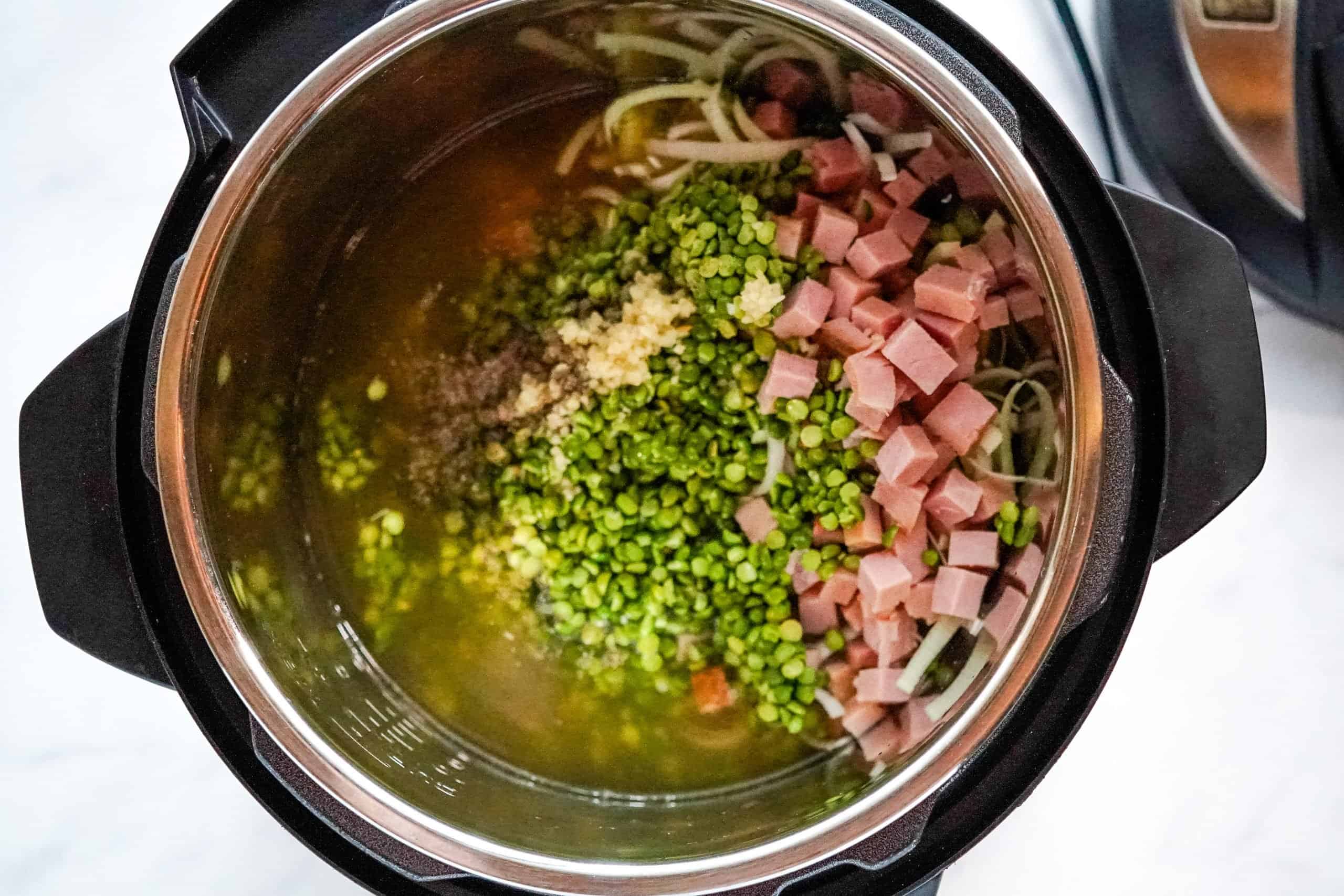 seasonings, garlic, dried split peas and chicken broth added to the instant pot.