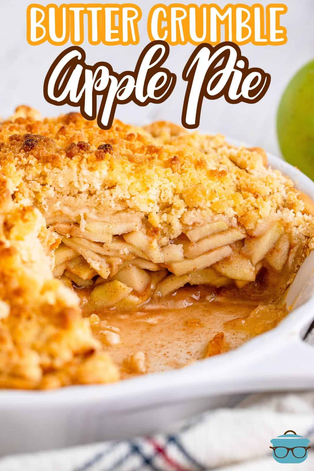 a butter crumble apple pie in a pie pan with one piece removed to expose the inside of the pie. 