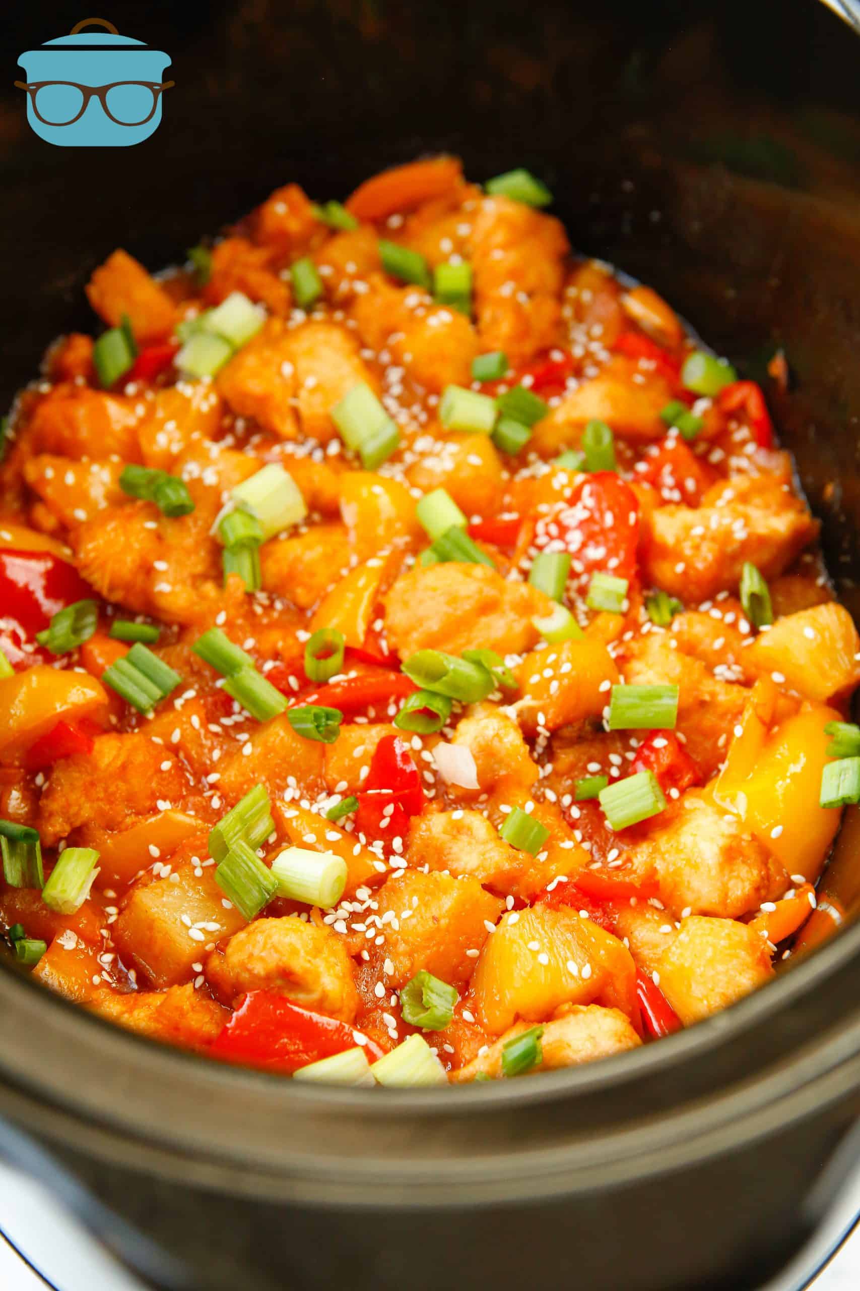 fully cooked Crock Pot Sweet and Sour Chicken, topped with sesame seeds and sliced green onion.