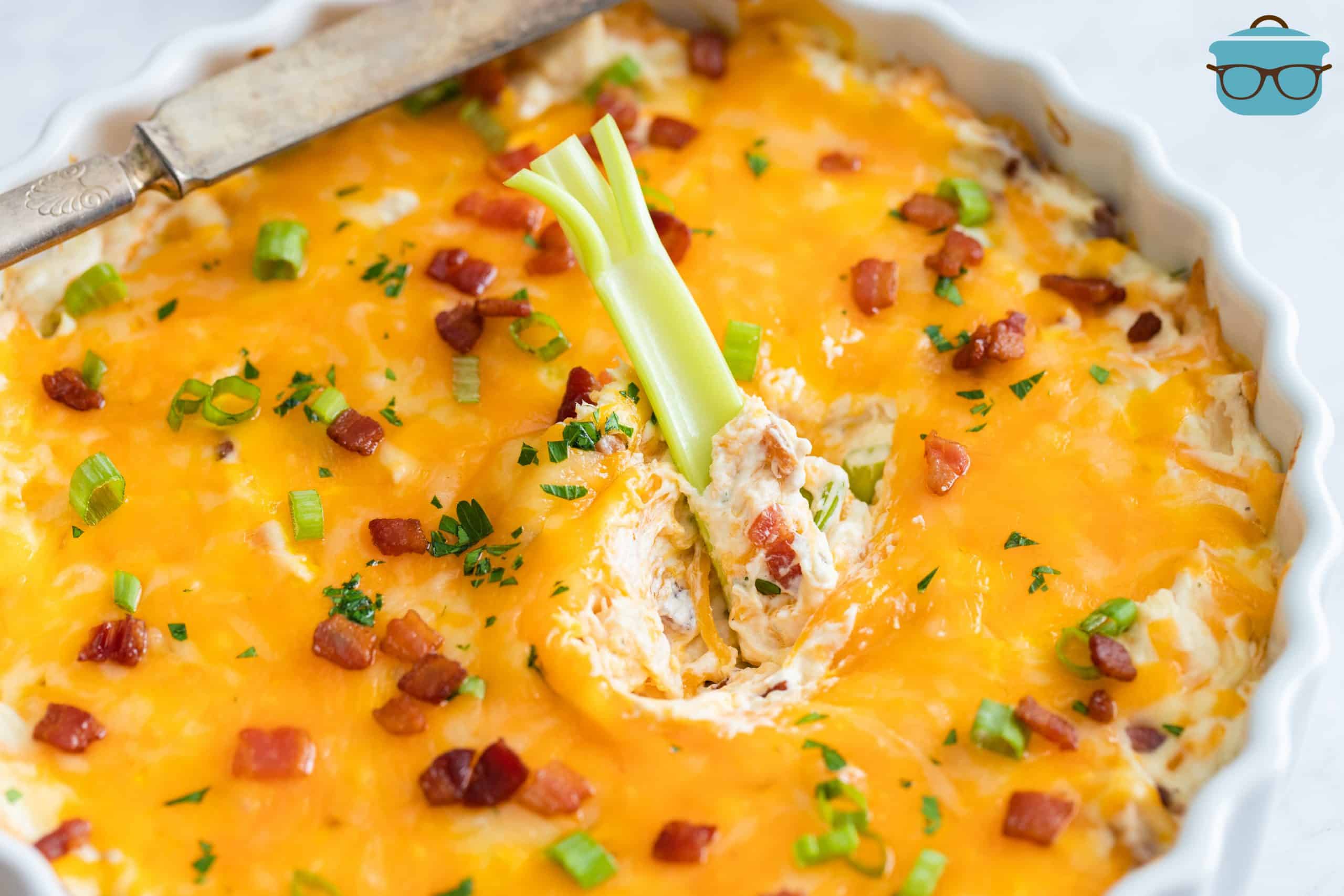 Crack Chicken dip with a celery stick dipped into the center of the dip.