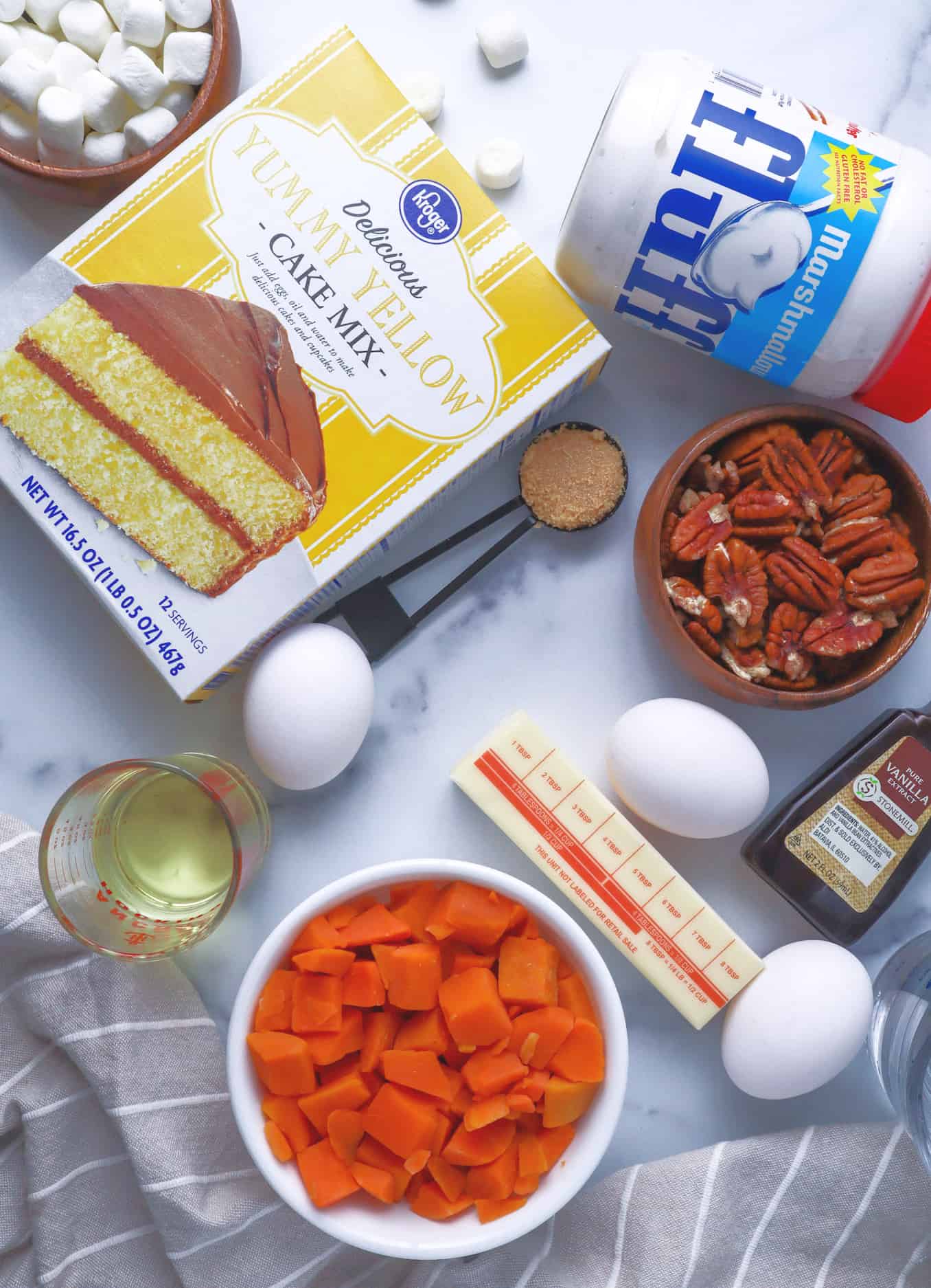 yellow cake mix, vegetable oil, large eggs, water, diced steamable sweet potato, marshmallow fluff, cream cheese ,unsalted butter, light brown sugar, chopped pecans.